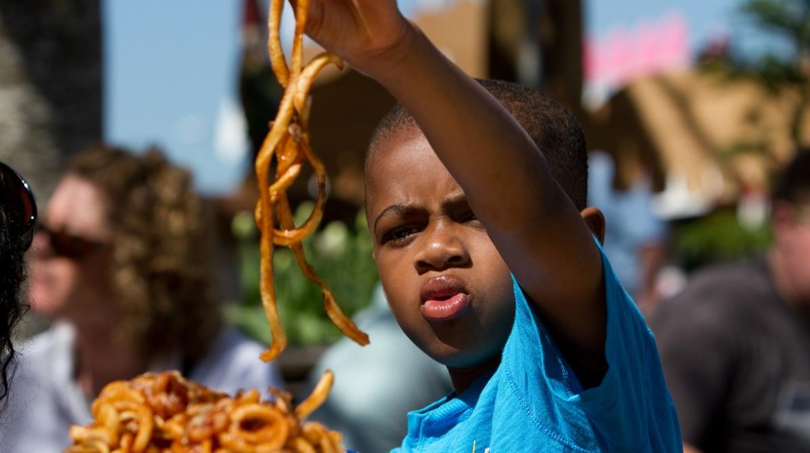 A boy at the Washington State Spring Fair in Puyallup, Washington, gazes at a huge pile of curly fries